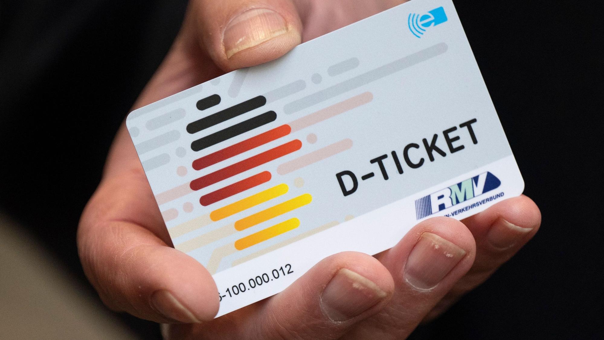 Eine Hand hält die Chipkarte eines Deutschlandtickets in der Hand.