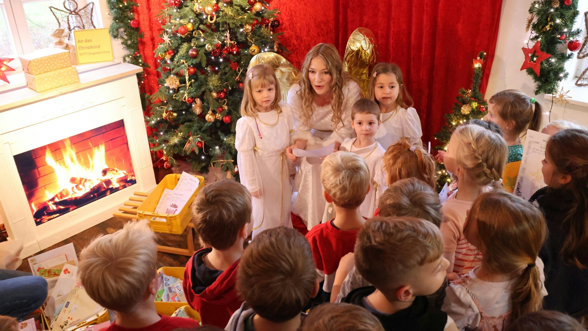 Ein Engel nimmt Wunschzettel von Kindern entgegen.