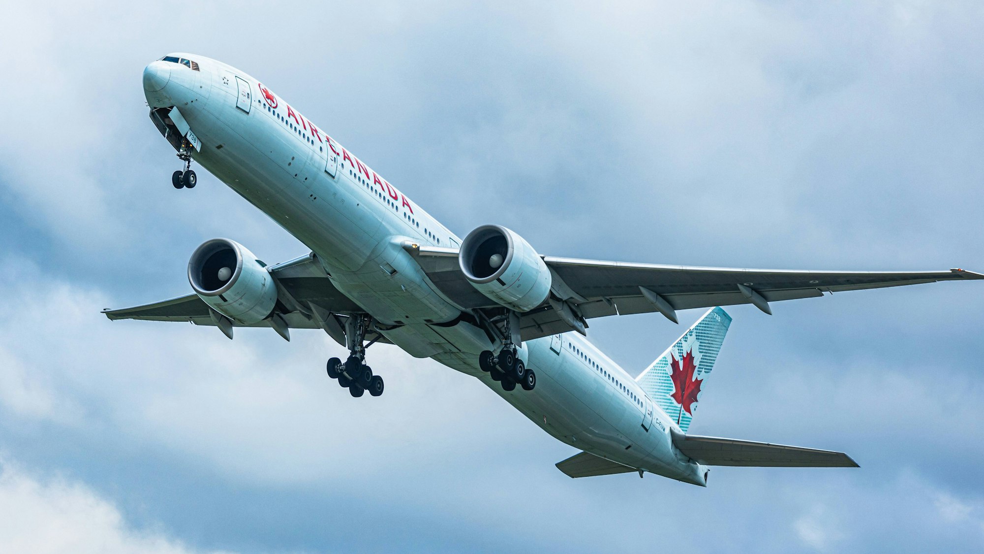 Eine Boeing 777 der kanadischen Fluggesellschaft Air Canada im Landeanflug auf einen Flughafen. Das Flugzeug ist rot-weiß lackiert. (Symbolbild)