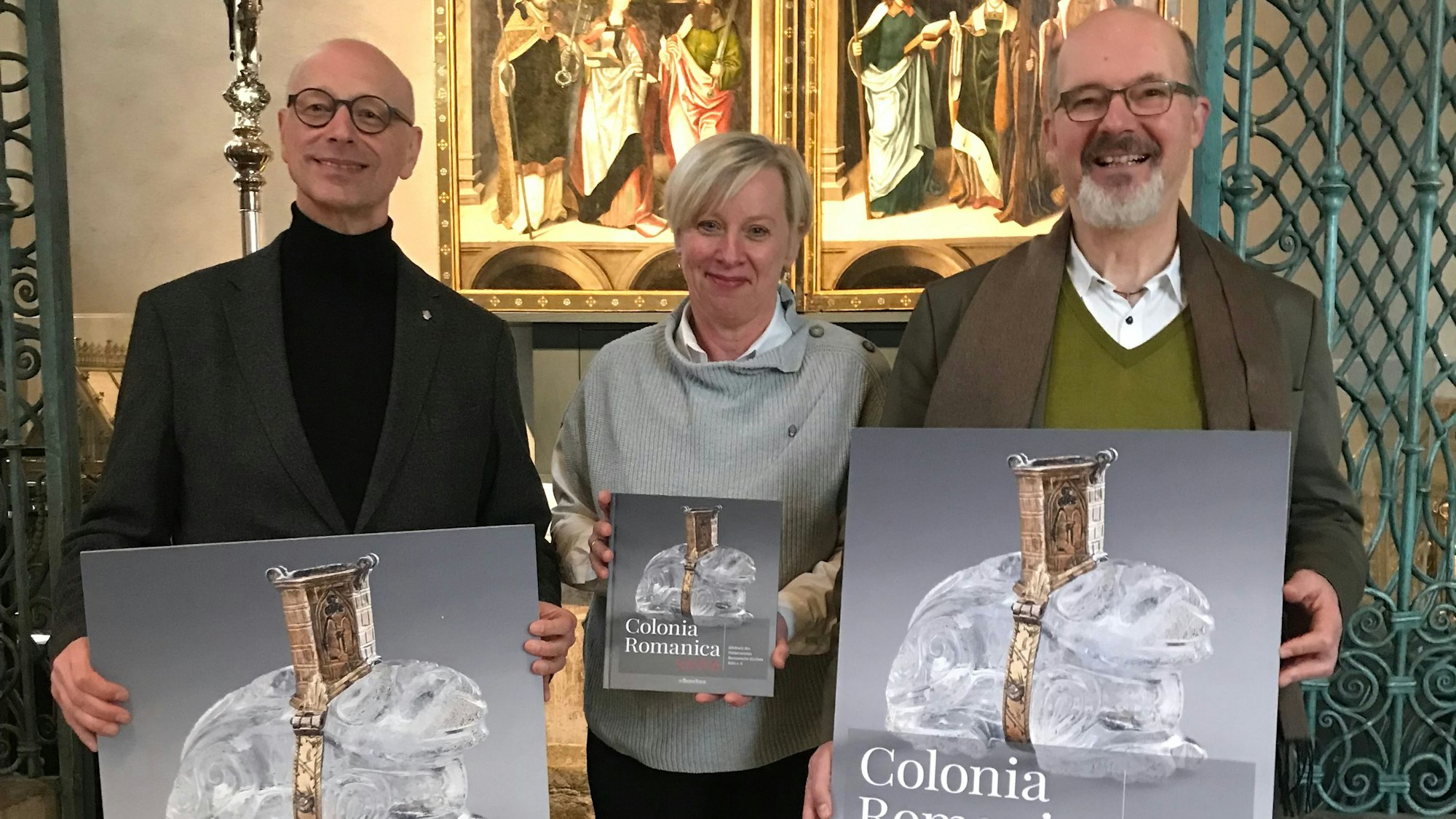 Zu sehen sind (v.l.) Helmut Loggen, Vorsitzender des Fördervereins Romanische Kirchen, Gabriele Oepen-Domschky, Geschäftstführerin des Fördervereins, und Stephan Ch. Kessler, Pfarrer an St. Peter.