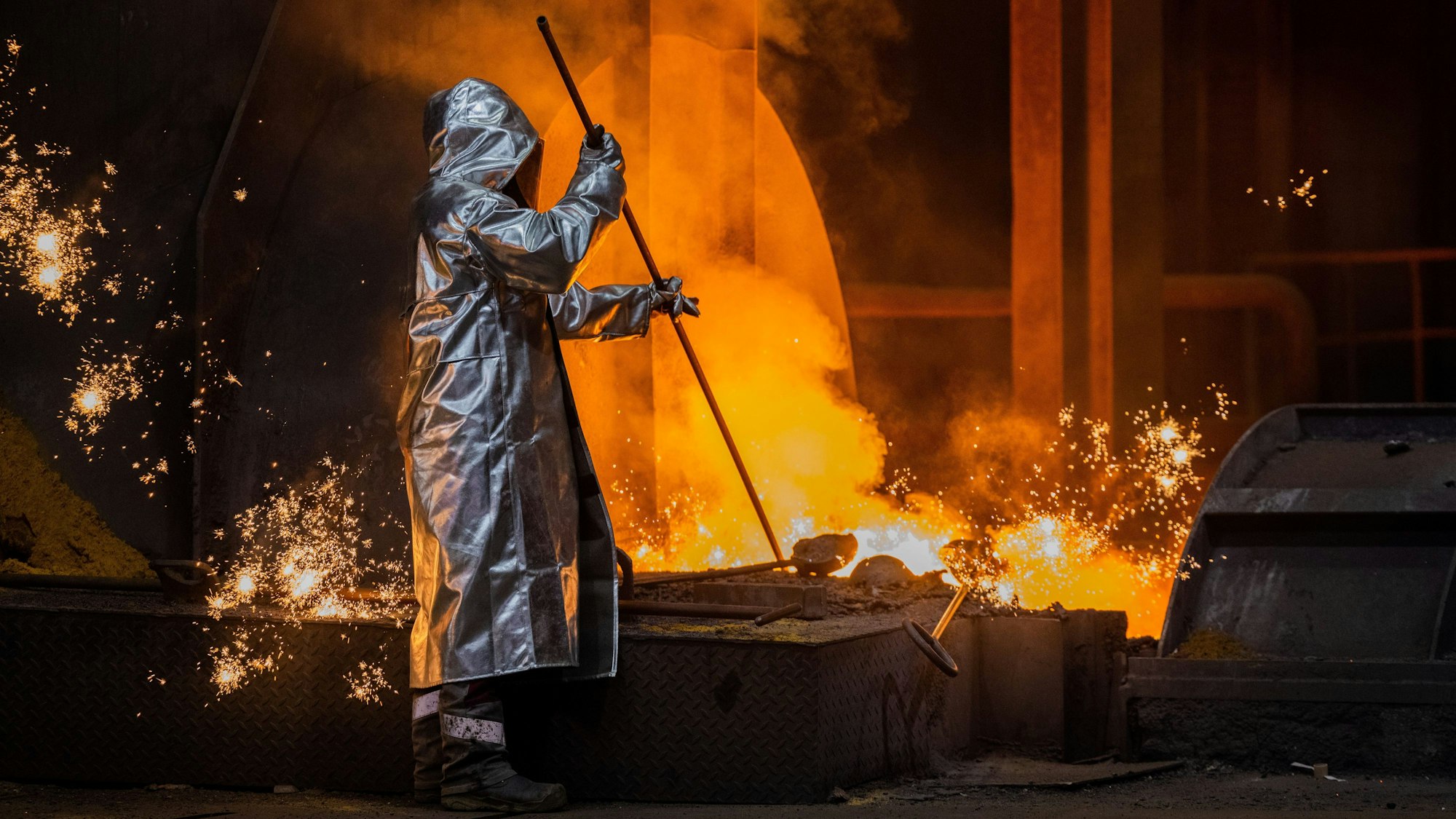 Ein Stahlarbeiter von Thyssenkrupp prüft den Roheisen am Hochofen 8 auf dem Werksgelände.