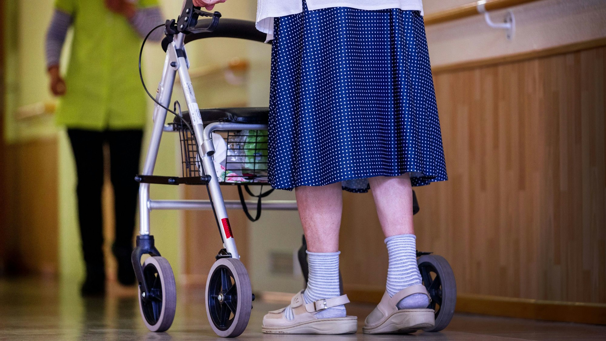Eine Bewohnerin mit ihrem Rollator in einem Pflegeheim