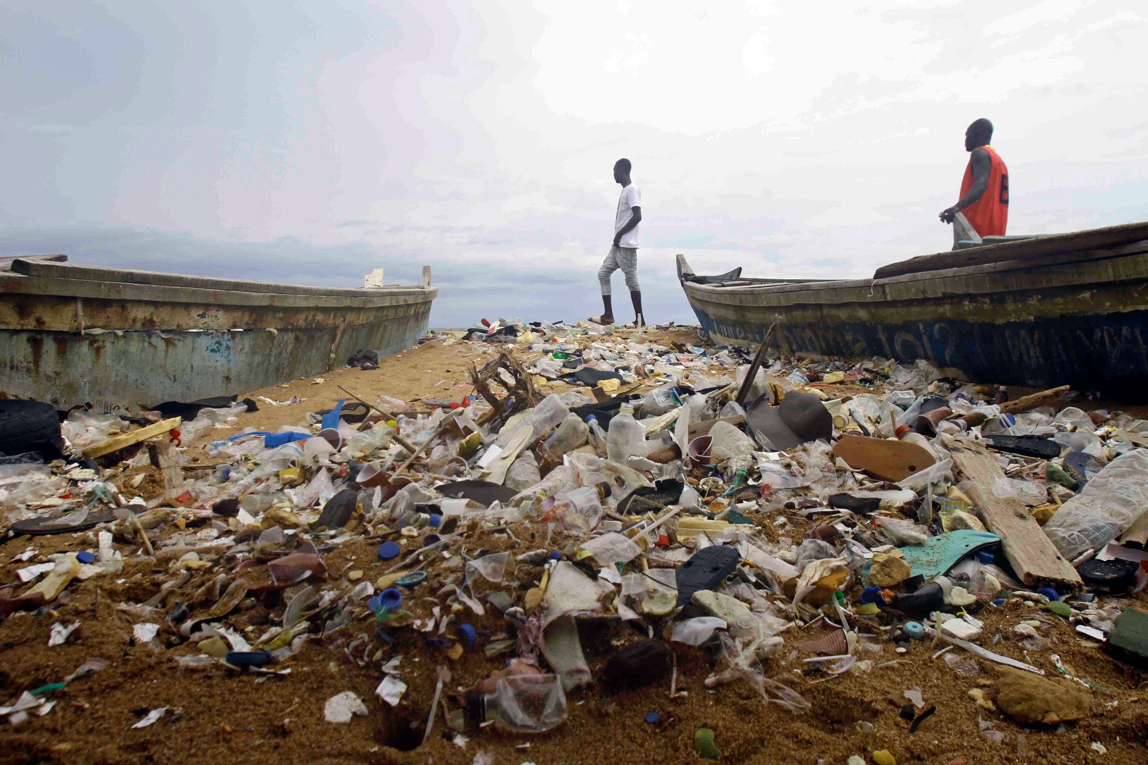 Menschen spazieren am 2. Juni 2023 über den mit Plastik verschmutzten Strand von Port Bouet außerhalb von Abidjan, Elfenbeinküste.