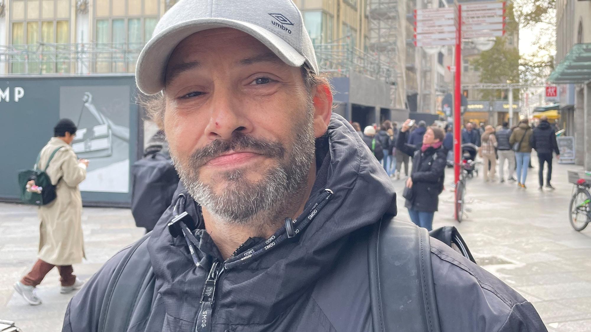 Ein Mann mit grauer Kappe steht vor dem Dom