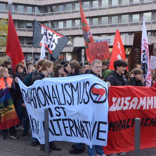 Demonstranten vor der Stadthalle, im Hintergrund ist das Troisdorfer Rathaus zu sehen. Die Demonstranten tragen Transparente mit Aufschriften wie „Nationalismus ist keine Alternative“.
