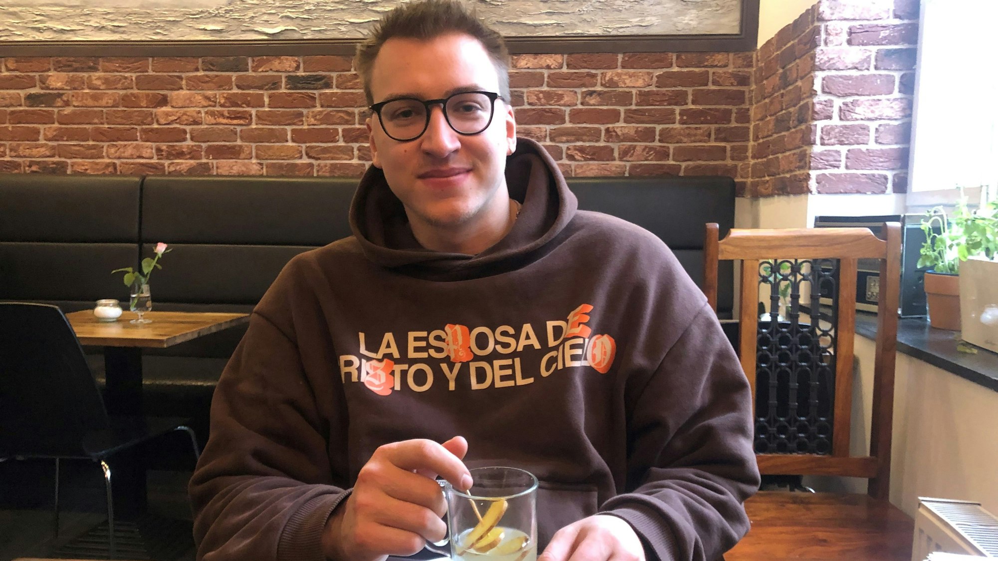 Junger Mann mit Ingwer-Tee im Café