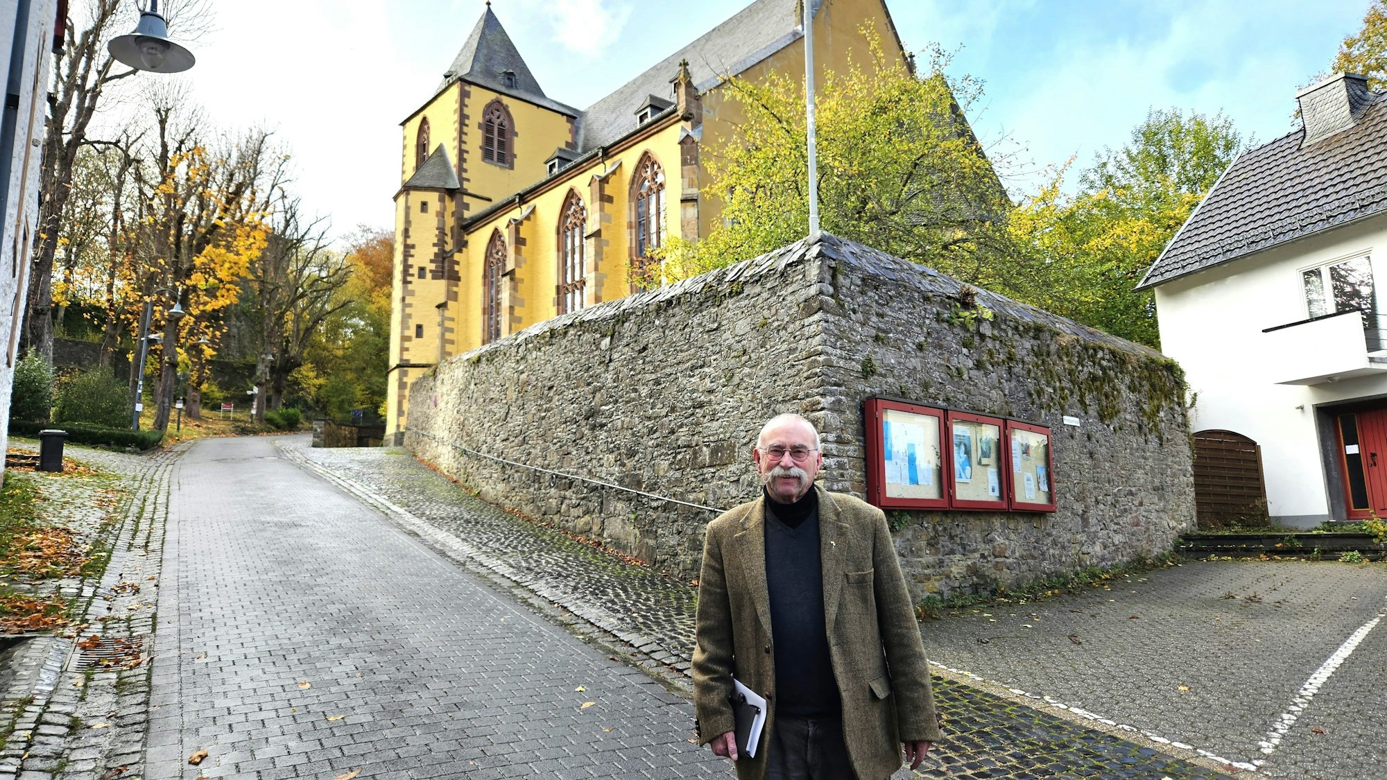 Pfarrer Philipp Cuck aus Schleiden steht vor der Schlosskirche