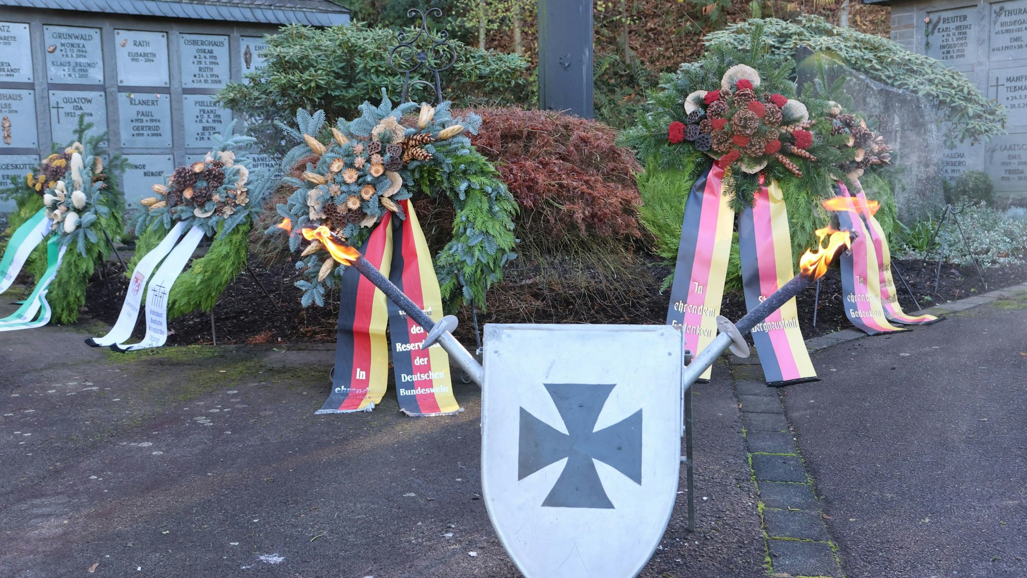 Man sieht ein Schild mit Schwertern und Trauerkränze.