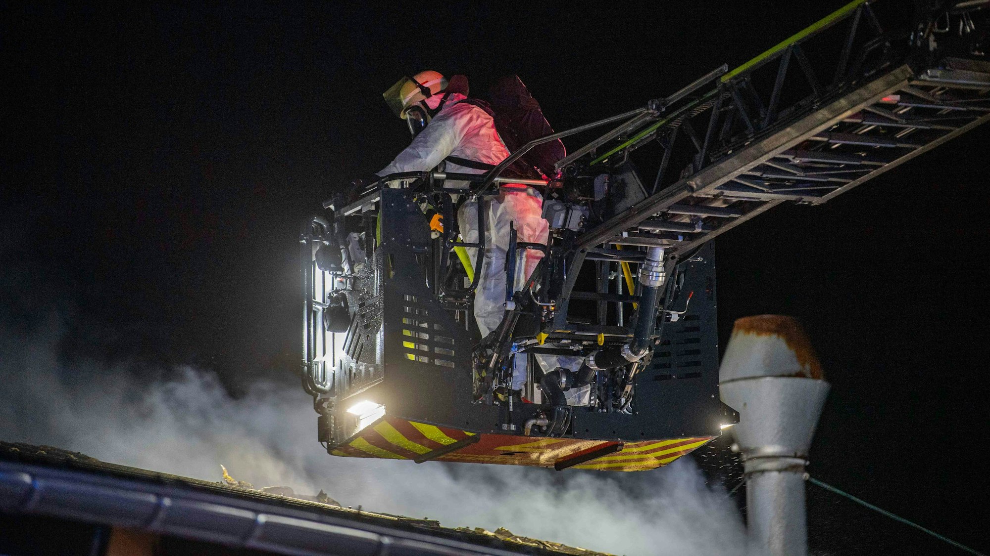 Das Bild zeigt einen Feuerwehrmann im Korb der Drehleiter.