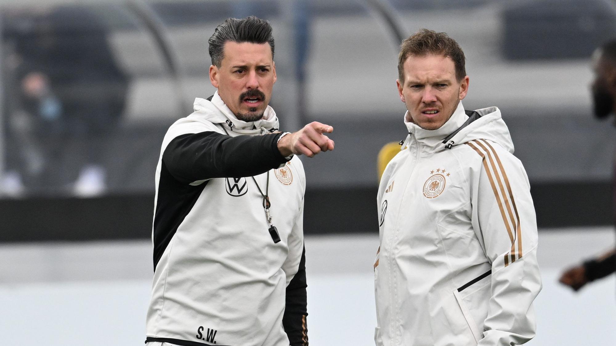 Bundestrainer Julian Nagelsmann (r) und Co-Trainer Sandro Wagner stehen beim Training der Nationalmannschaft auf dem DFB-Campus zusammen.