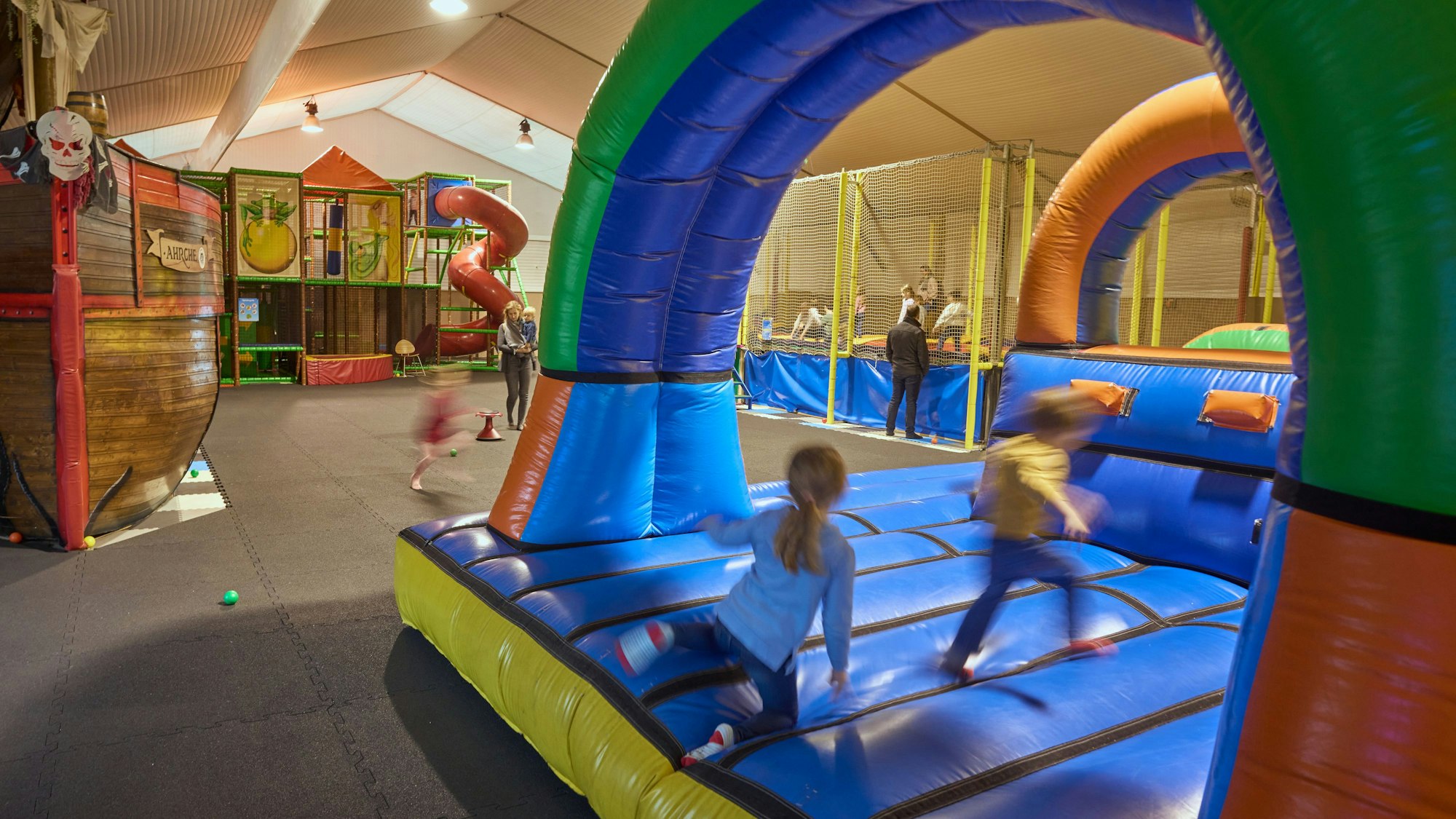 Kinder toben ine inem Indoor-Spielpark Kinderpark.