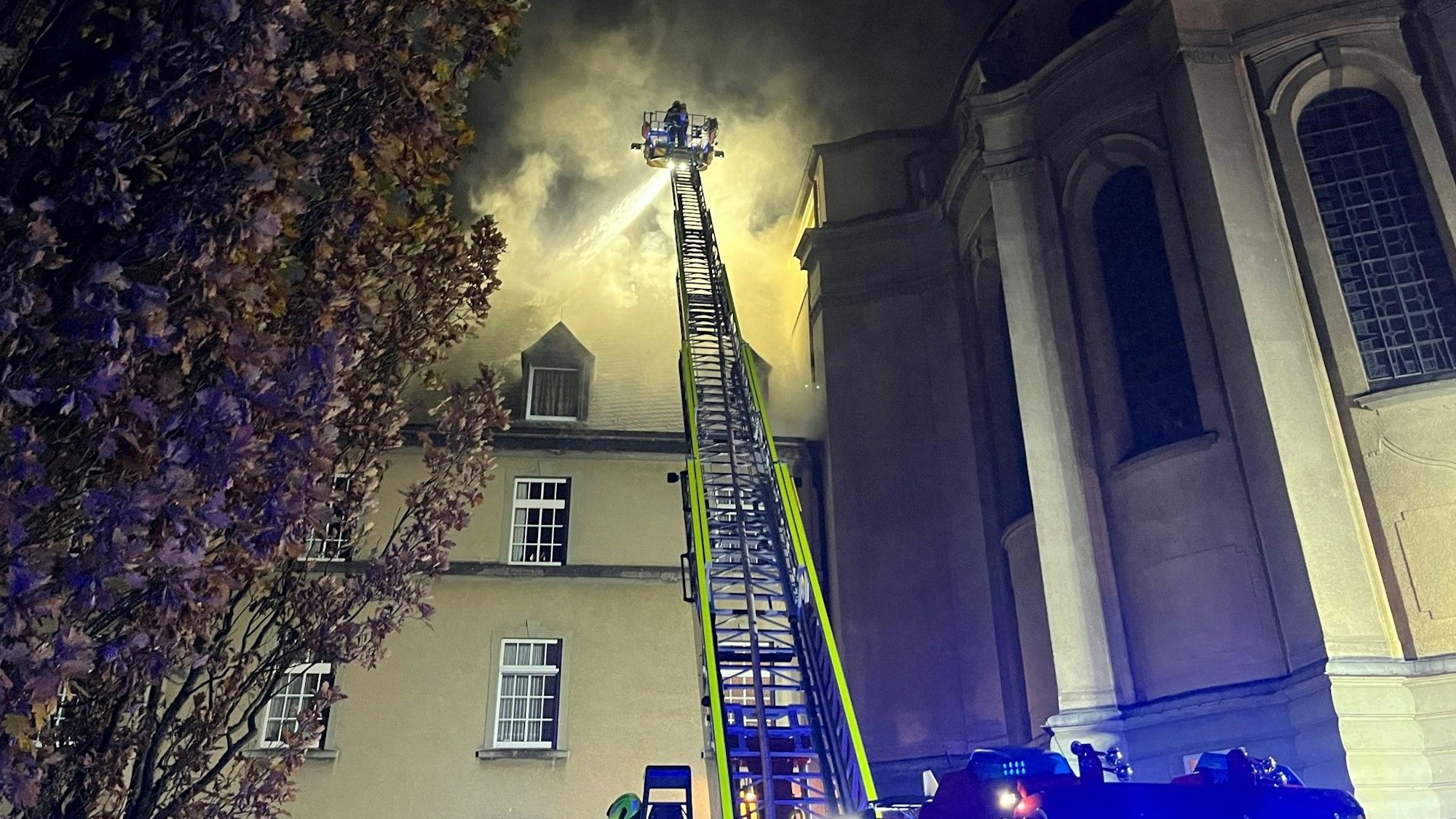 In eienm Gebäude der Steyler Missionare in Sankt Augustin brennt es im Dachgeschoss. Die Feuerwehr Sankt Augustin ist mit der Drehleiter im Einsatz und kämpft gegen die Fammen in dem historischen Gebäude.