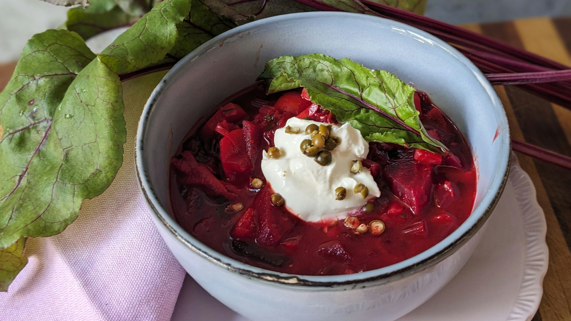 Ein Klecks Schmand und gehackter grüner Pfeffer auf dem Rote Bete-Eintopf.