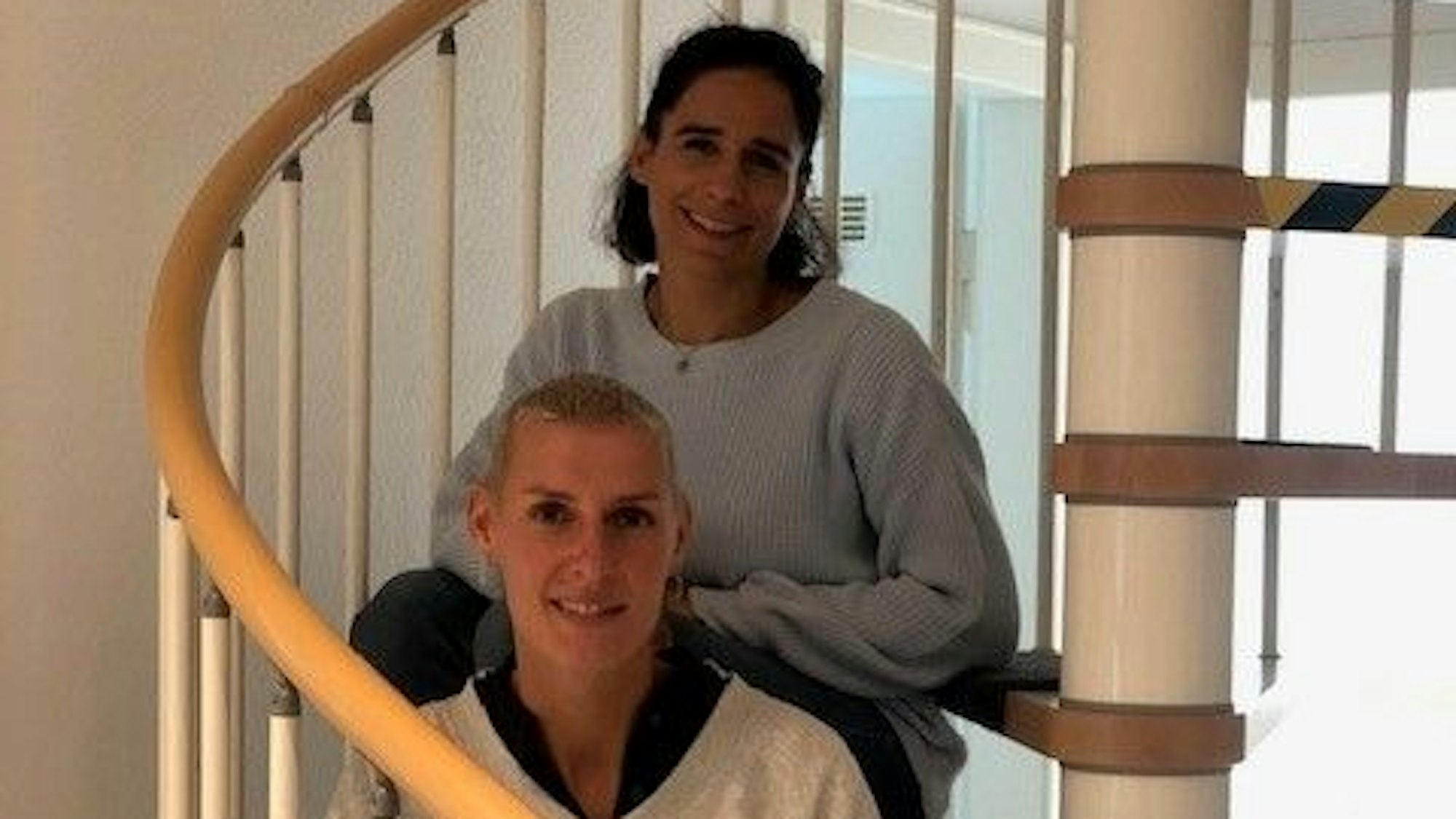 Zwei Frauen sitzen auf einer Wendeltreppe in der Notschlafstelle für junge Frauen, es sind die Leiterin Maren Rasch und die Sozialarbeiterin Louisa Käser