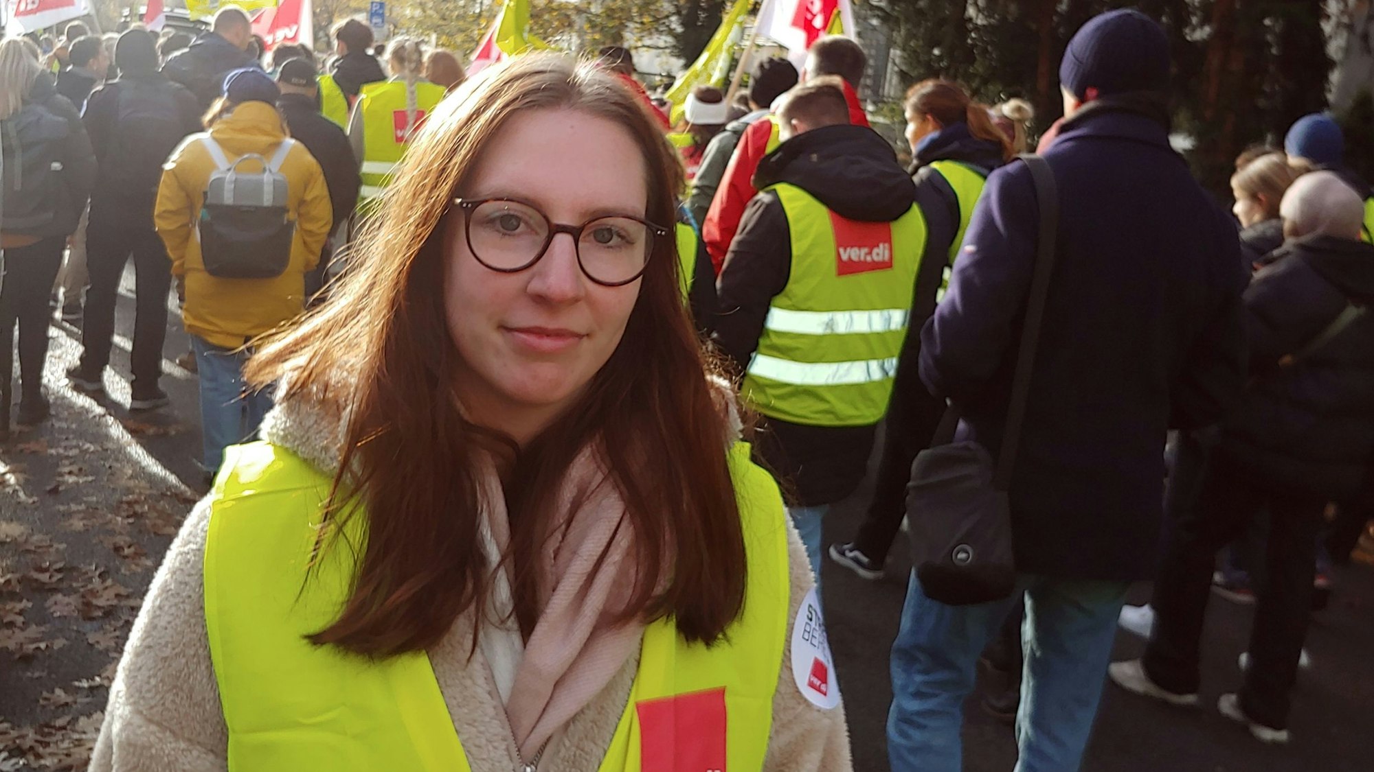 Junge brünette Frau mti Brille in einer gelben Warnweste