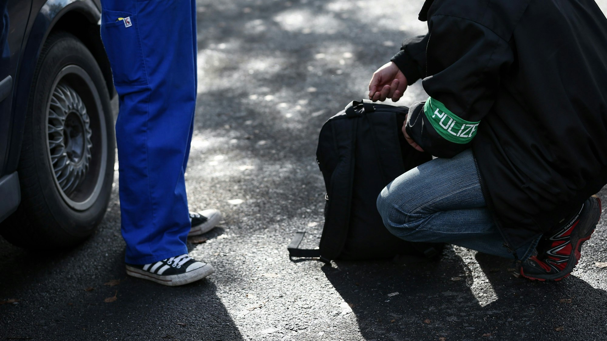 Ein Polizeibeamter durchsucht einen Rucksack.