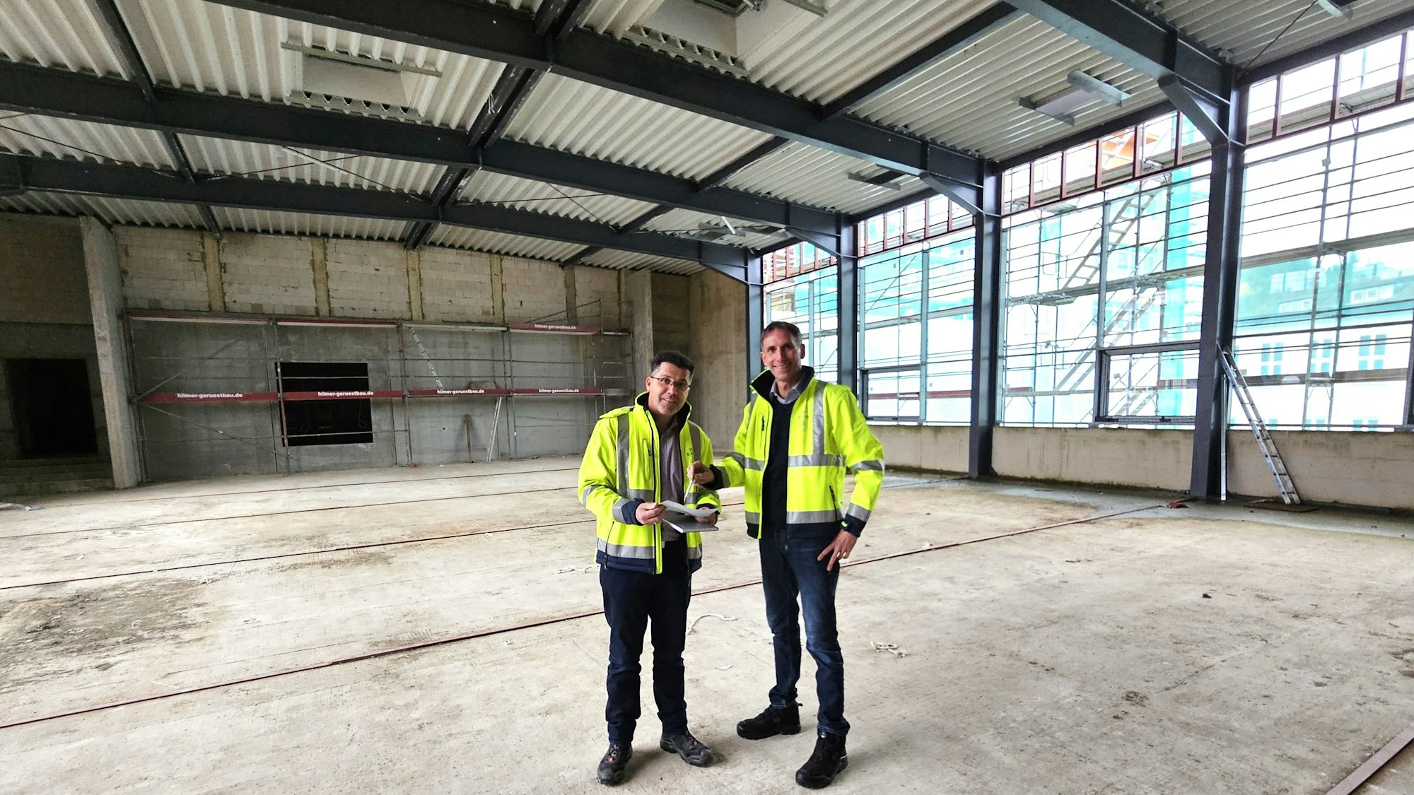 Armin Fischbach (l.) und Marcel Wolter stehen in dem Rohbau der Bürgerhalle.