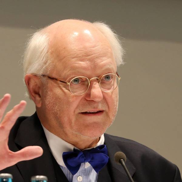 Franz Xaver Ohnesorg spricht in ein Mikro. Er trägt einen dunklen Anzug und eine blaue Fliege.