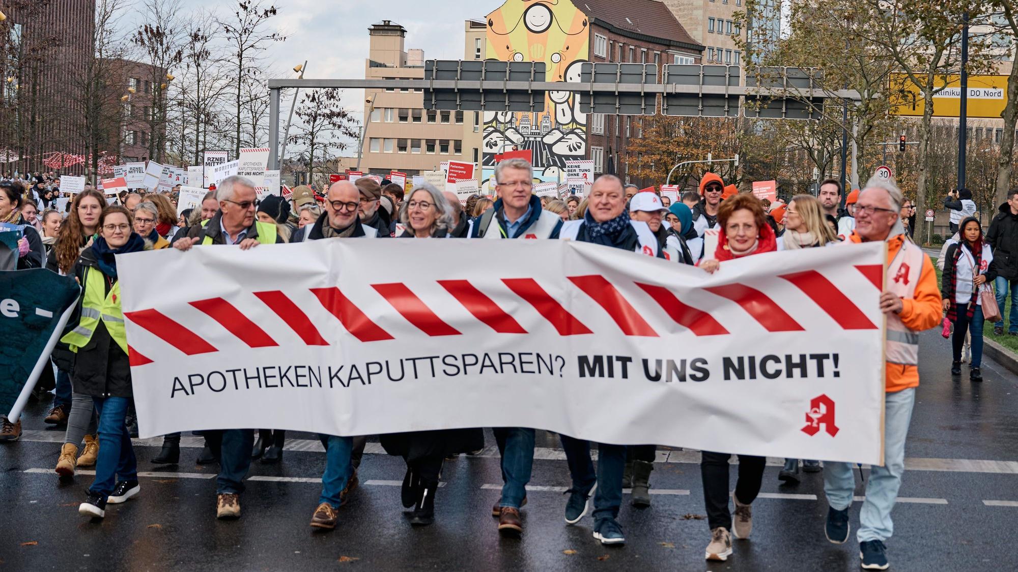 Plakate und Transparente sind bei der zentralen Kundgebung für den Apotheken-Protest zu sehen.