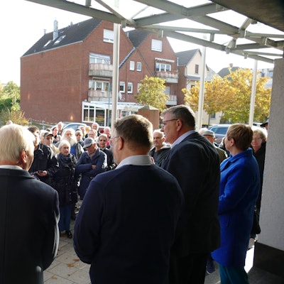Gegner der Niederkasseler Grundsteuererhöhung stehen bei der Übergabe ihrer Petition vor dem Niederkasseler Rathaus und diskutieren mit dem damaligen Bürgermeister Stephan Vehreschild.