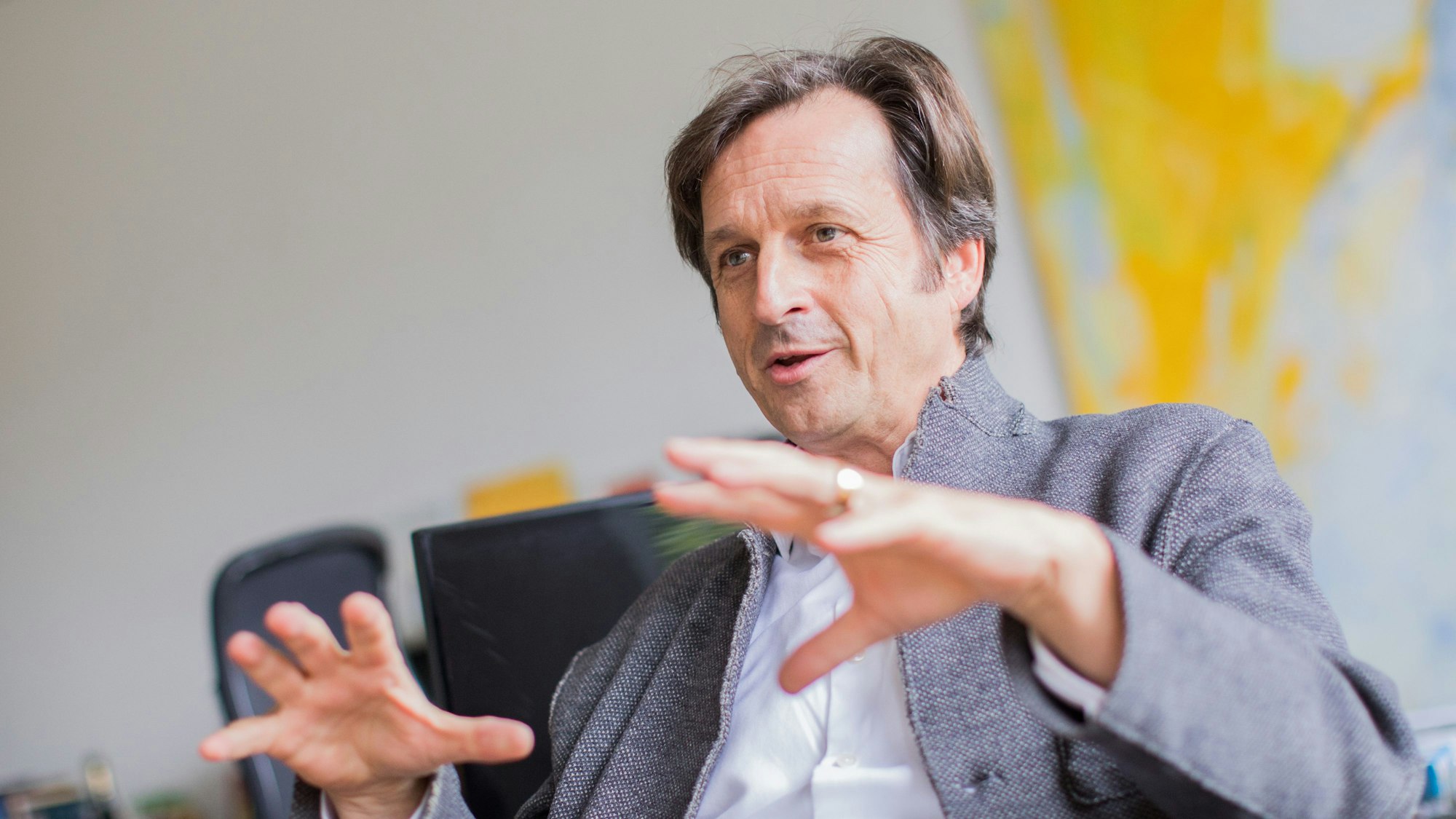 Stephan Grünewald gestikuliert mit seinen Händen, während er spricht.