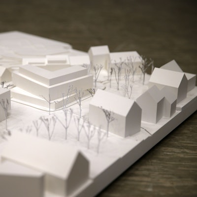 Ein weißes Holzmodell der Innenstadt zeigt ein eckiges, dreigeschossiges Flachdachhaus am Standort des alten Hotels.