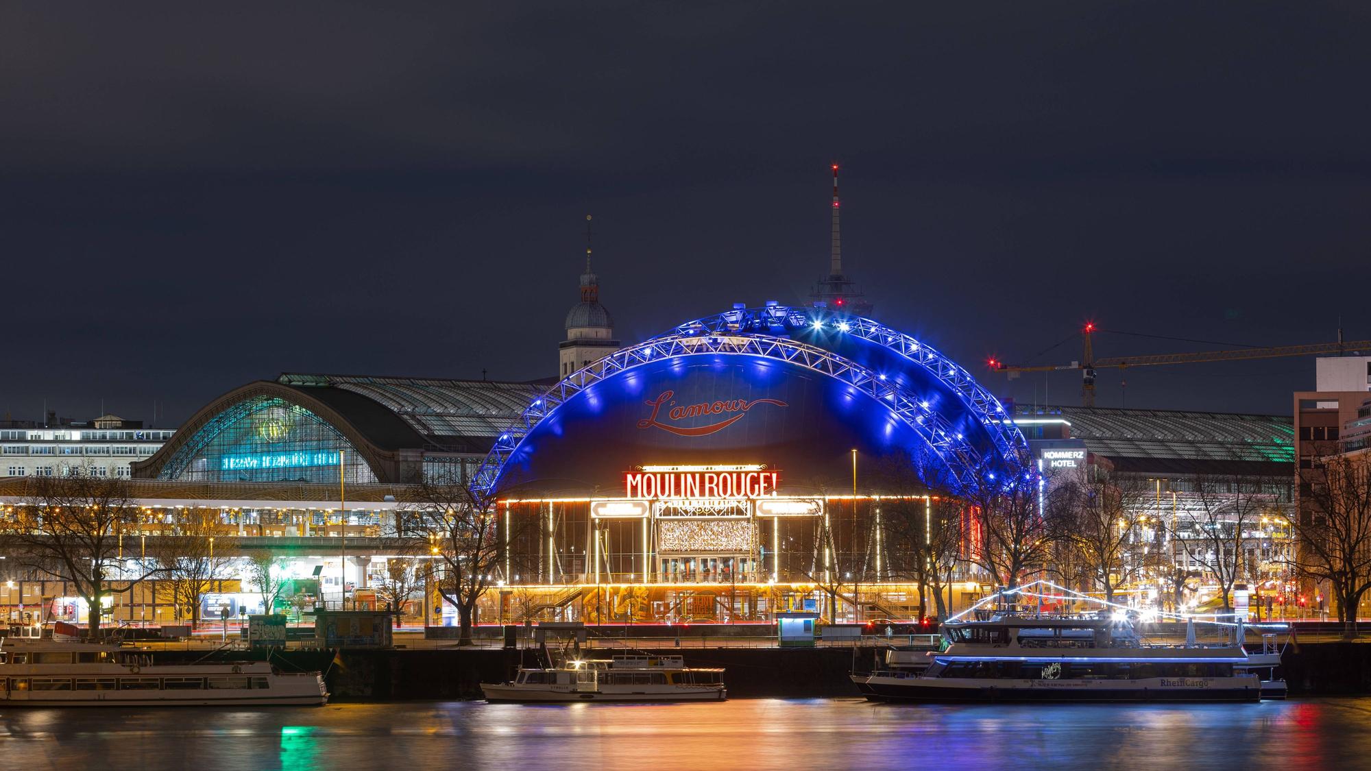 Blick bei Nacht vom Deutzer Rheinufer an der Hohenzollernbrücke auf den Musical Dome am Kölner Hauptbahnhof.