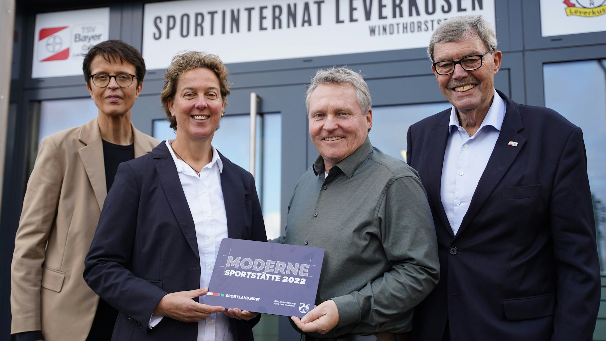 Anne Wingchen (Geschäftsführerin TSV Bayer 04 Leverkusen), Steffi Nerius (Leiterin Sportinternat Leverkusen), Detlef Berthold (Staatskanzlei NRW) und Klaus Beck (Vorsitzender TSV Bayer 04 Leverkusen) vor dem neuen Eingang des Sportinternats.