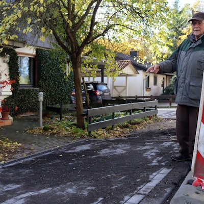 Michael Bolten zeigt auf die abschüssige Zuwegung zwischen Straße und seinem Grundstück.