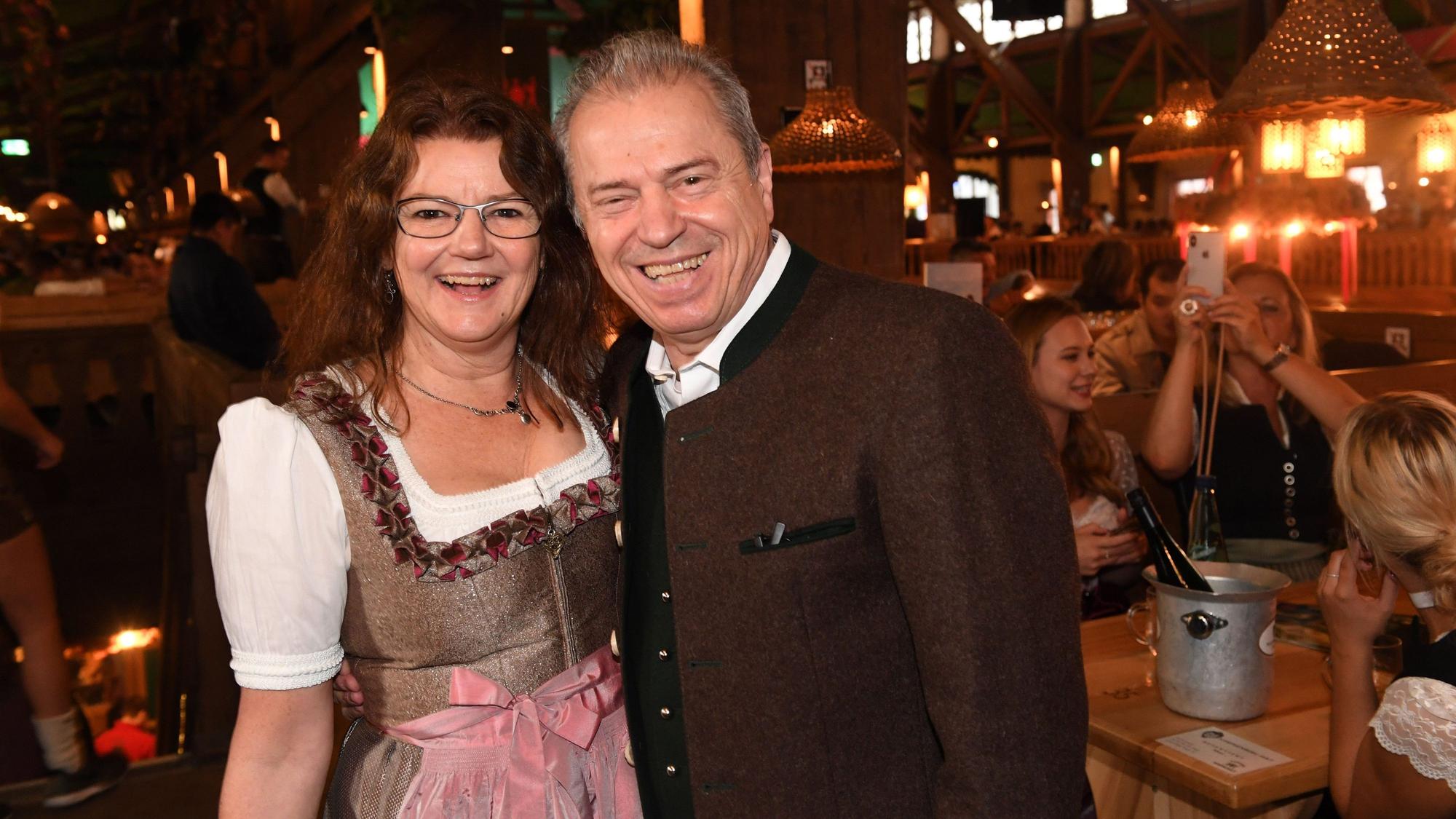 Günther und Doris Sigl lächeln in bayerischer Tracht in die Kamera - sie stehen in einem Festzelt.