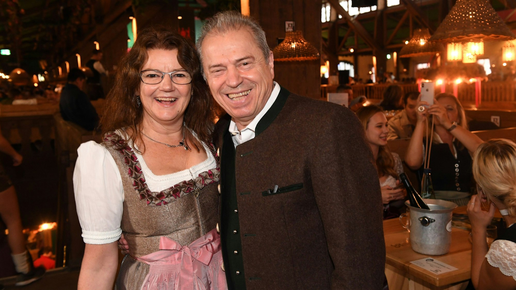 Günther und Doris Sigl lächeln in bayerischer Tracht in die Kamera - sie stehen in einem Festzelt.