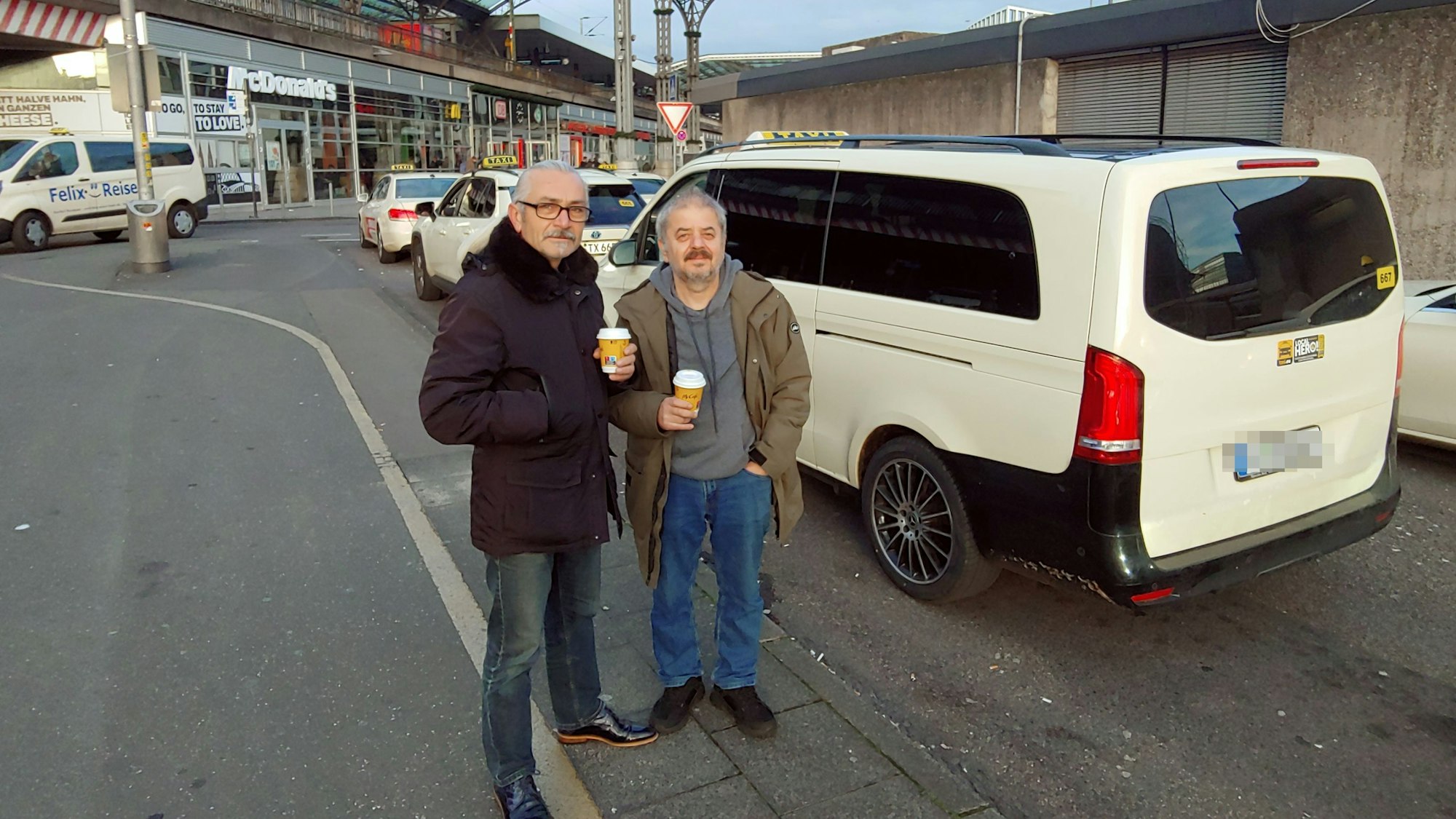 Zwei Männer stehen vor einem Taxi
