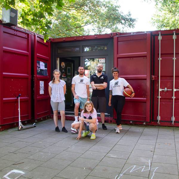 Das Team der„ Grembox“, der Jugendeinrichtung der „Rheinflanke“ in Gremberghoven, steht vor einem ehemaligen Seecontainer, der jetzt eine Jugendeinrichtung ist.