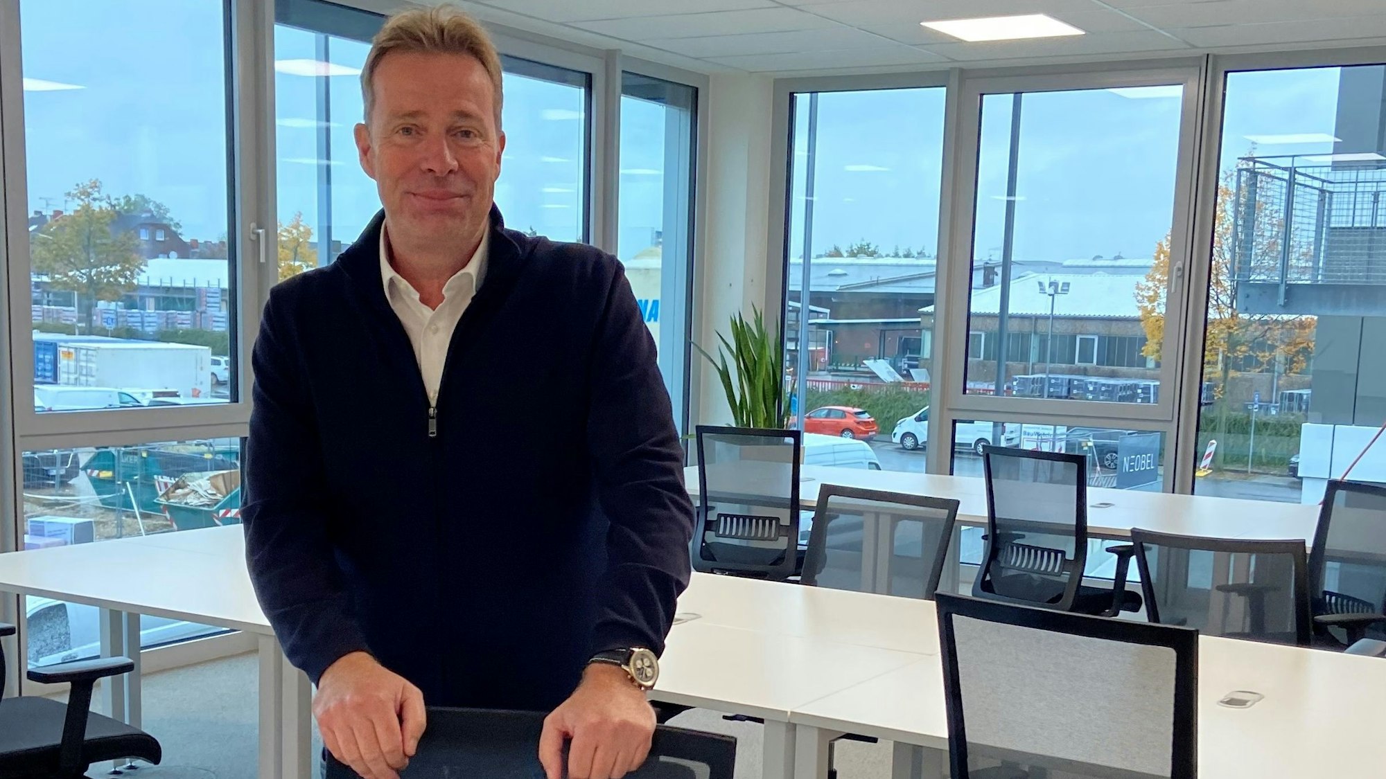 Auf dem Bild ist ein Mann zu sehen, der in einem Büroraum steht.