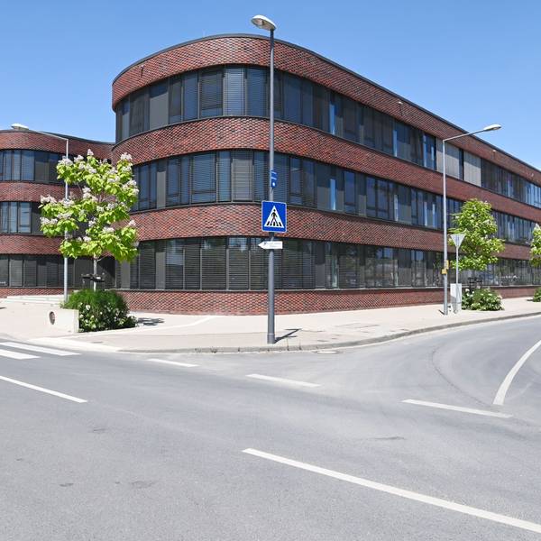 Außenaufnahmen eines Gebäudes, das früher ein Bürogebäude war und dann als Schulgebäude umgeplant wurde.