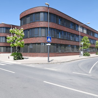 Außenaufnahmen eines Gebäudes, das früher ein Bürogebäude war und dann als Schulgebäude umgeplant wurde.