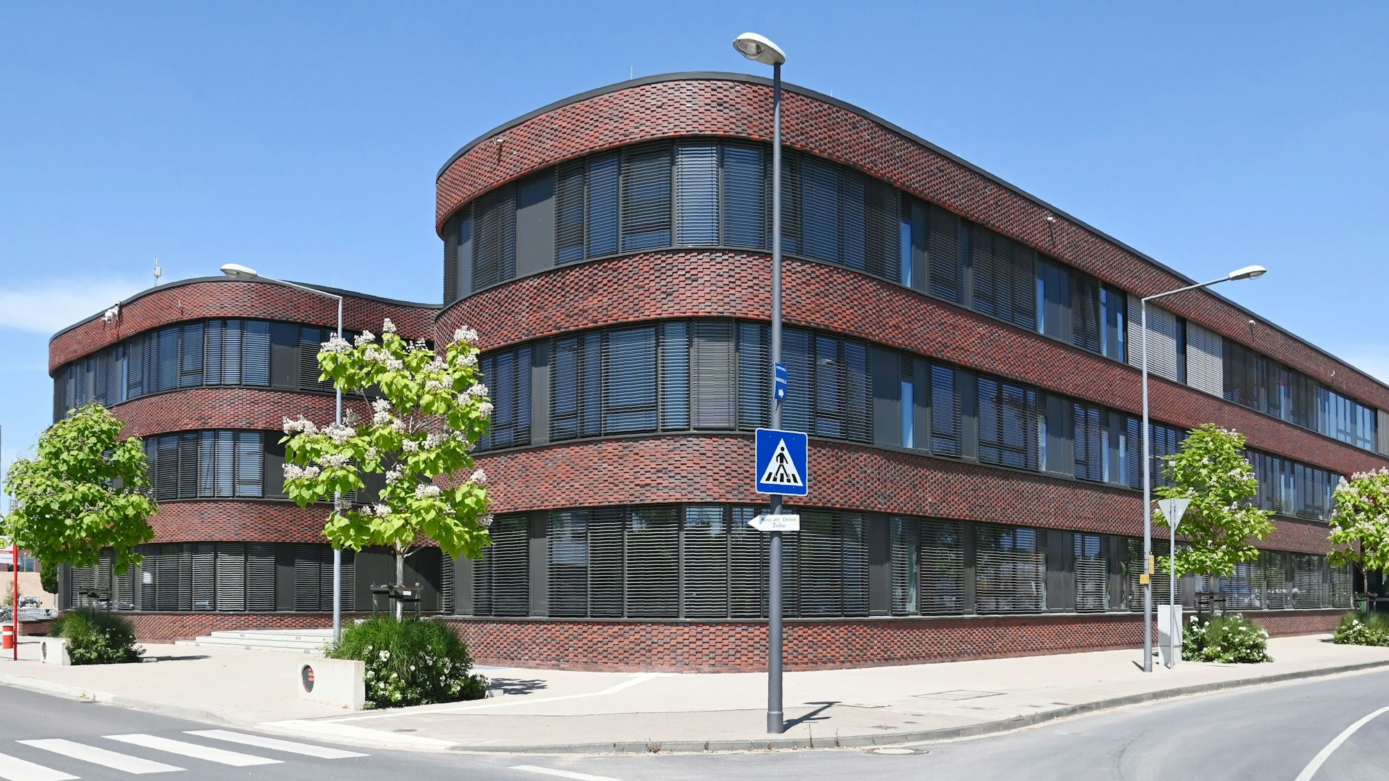 Außenaufnahmen eines Gebäudes, das früher ein Bürogebäude war und dann als Schulgebäude umgeplant wurde.