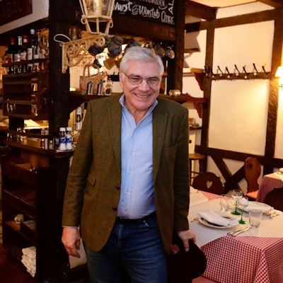 Romain Wack steht in seinem Lokal. Holzbalken und rot-weiß-karierte Tischdecken sind das Markenzeichen.