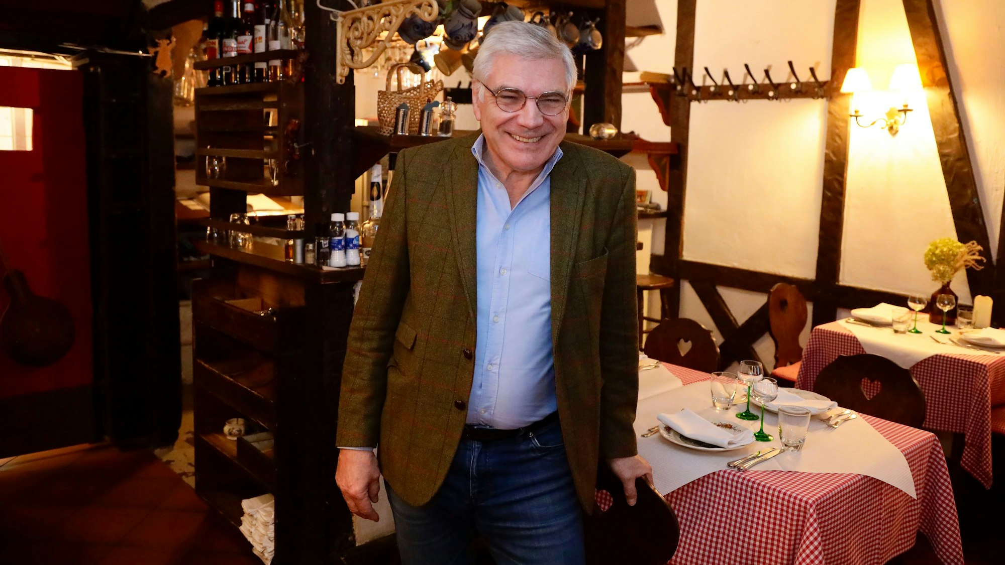 Romain Wack steht in seinem Lokal. Holzbalken und rot-weiß-karierte Tischdecken sind das Markenzeichen.