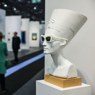 Eine weiße Büste Nofretete mit Sonnenbrille.