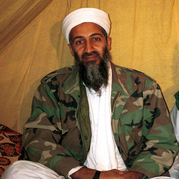 Osama bin Laden in Camouflage-Jacke vor einem hellen Hintergrund