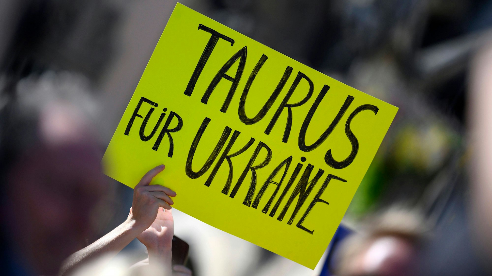 Ein pro-ukrainischer Demonstrant fordert auf einem Plakat „Taurus für Ukraine“ bei einer Rede von Bundeskanzler Olaf Scholz (SPD) auf dem Marienplatz in München. Am Donnerstag waren die Marschflugkörper erneut Thema im Bundestag. (Archivbild)