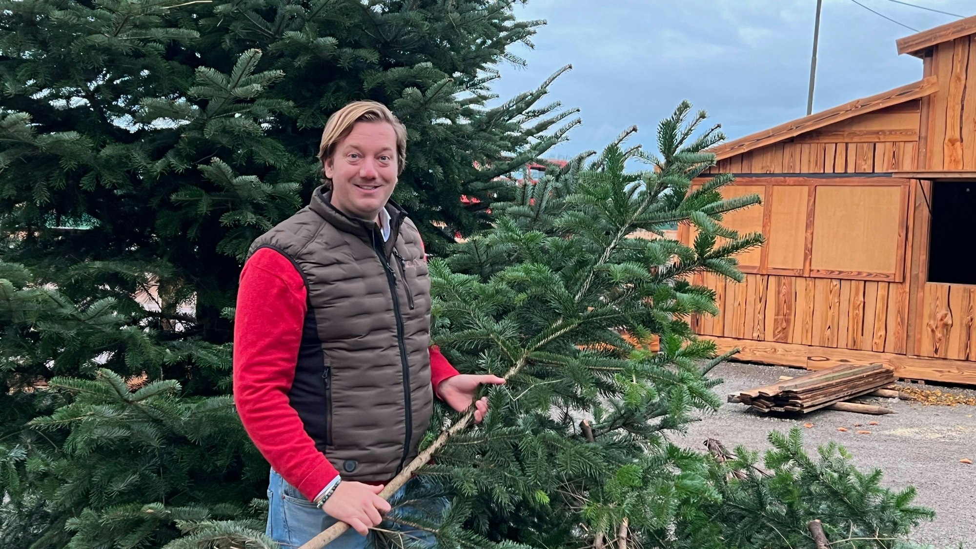 Das Bild zeigt Victor Dünn, der Inhaber von Gut Clarenhof, vor einem Weihnachtsbaum.