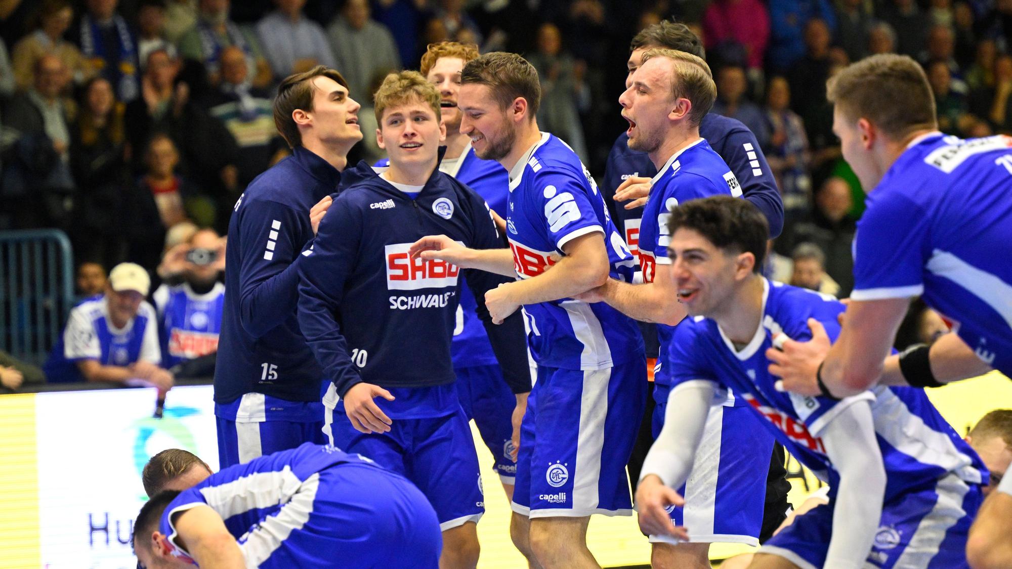 Mehrere Spieler des VfL Gummersbach stehen als Gruppe zusammen und freuen sich über den Sieg. In ihrer Mitte ist auch Spieler Finn Schroven.