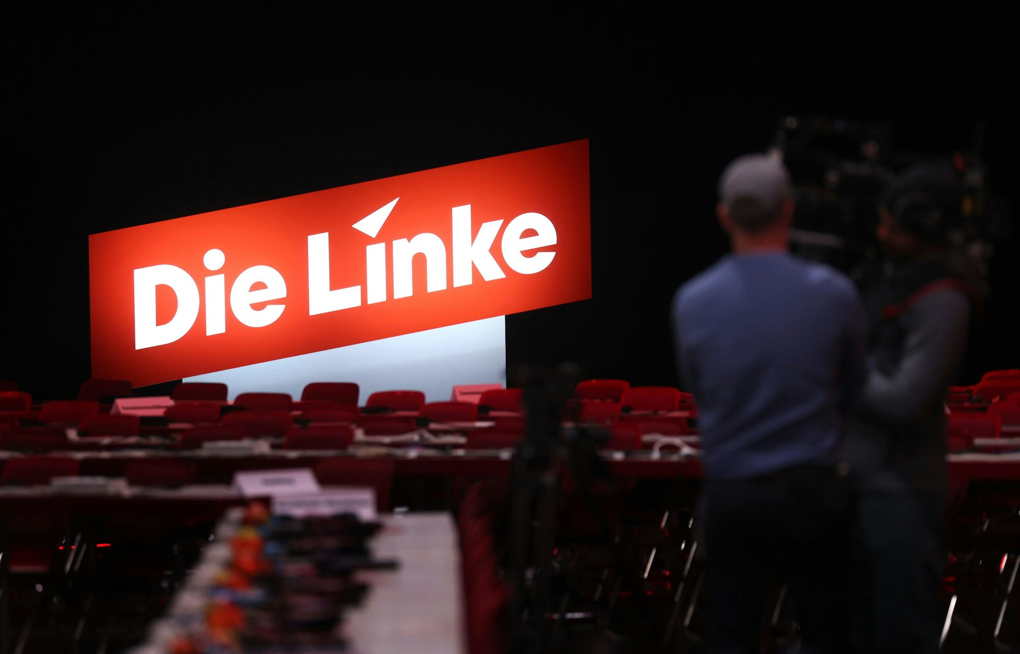 Ein Kamerateam steht vor dem neuen Logo der Partei.