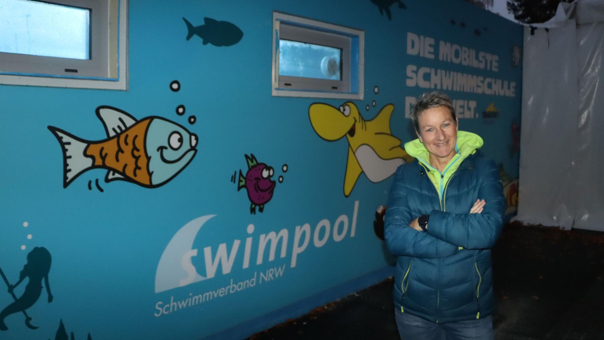 Das Foto zeigt Sylke Hindrichs vom Stadtsportverband Erftstadt vor dem Schwimmcontainer.