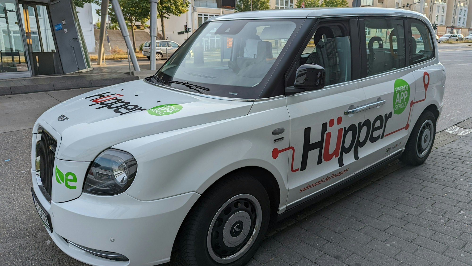 Ein Großraumtaxi mit der Aufschrift Hüpper am Busbahnhof in Hürth-Mitte.