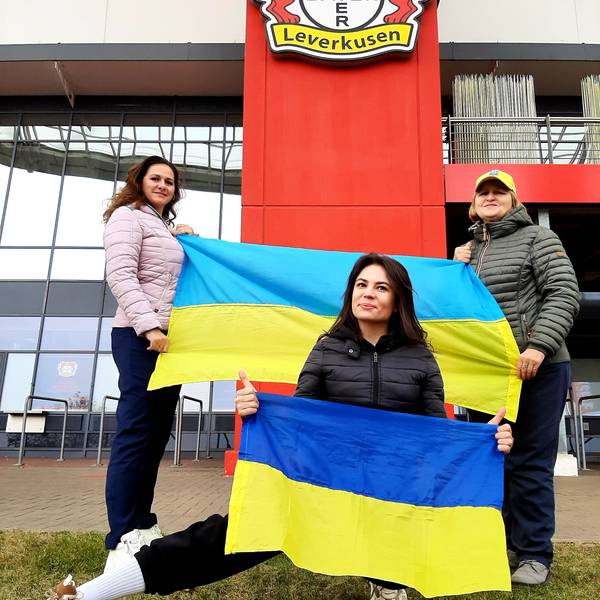 Die Ukrainerinnen (v.l.) Bilozin Liubov, Viktoriia Zhevlova und Nadiia Shepel stehen mit Ukraine-Flaggen vor der Bay-Arena, wo am kommenden Montag, 20. November,das Qualifikationsspiel zur Fußball-Europameisterschaft 2024 zwischen der Ukraine und Italien stattfindet.