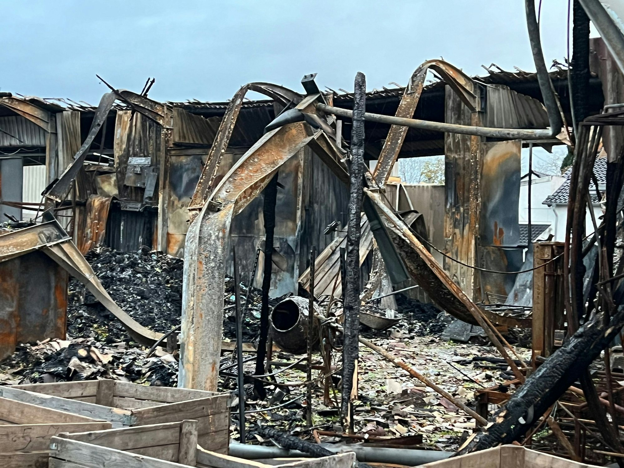 Das Bild zeigt das Gerippe einer ausgebrannten Lagerhalle.