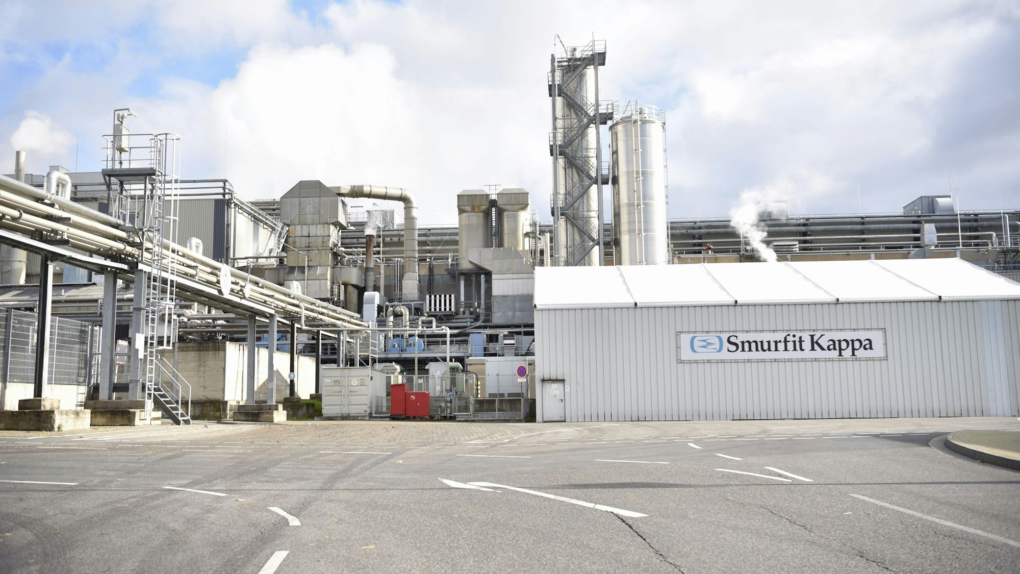 Das Bild zeigt eine Fabrik, auf einem Schild steht in großen Buchstaben Smurfit Kappa.
